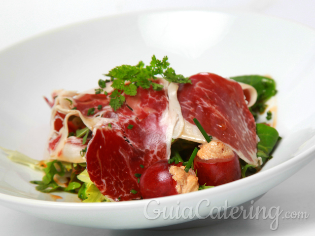 Ensalada de jamón ibérico con pasas, piñones y uvas rellenas de foie